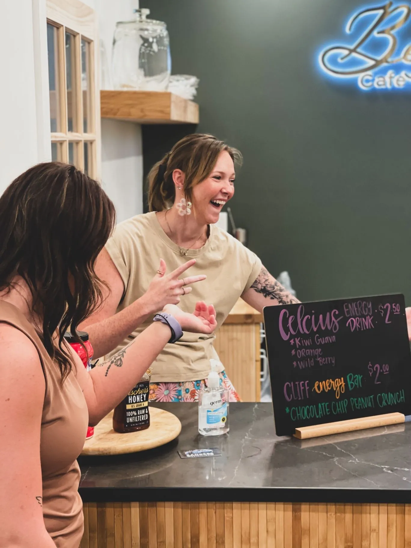 Friends laughing together at the Bella’s Café counter