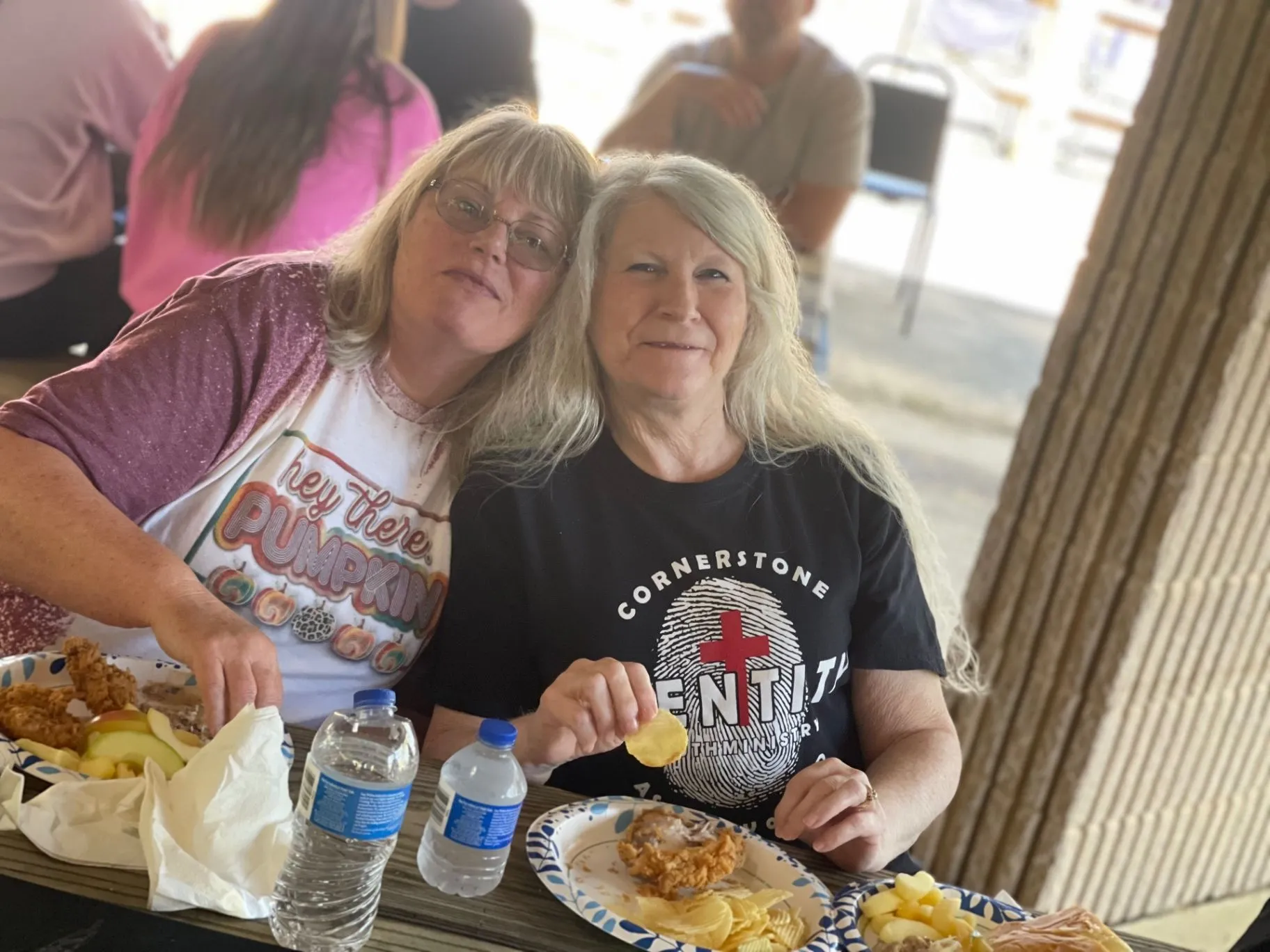Two friends sharing a meal during a Cornerstone Church fellowship gathering